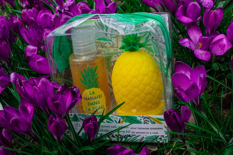 A travel kit with a cup in the shape of a pineapple and matching shower oil