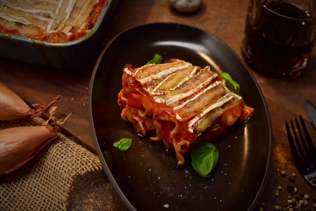 Überbackene Cannelloni schick angerichtetr in einer schwarzen Auflaufform