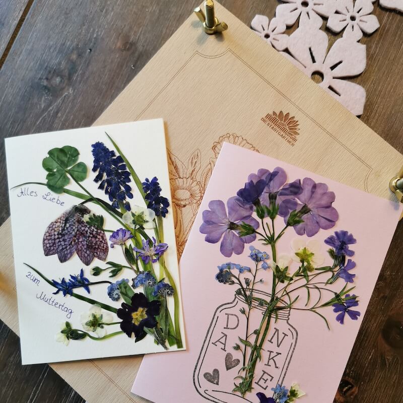 Zwei handgefertigte Grußkarten mit gepressten Blumen und den Wünschen Alles Liebe zum Muttertag und Danke.