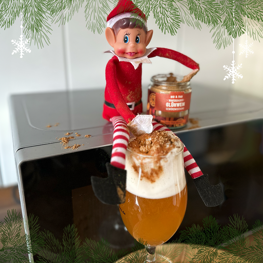 Der Elf verfeinert ein frisch gezapftes Bier mit Glühweingewürz