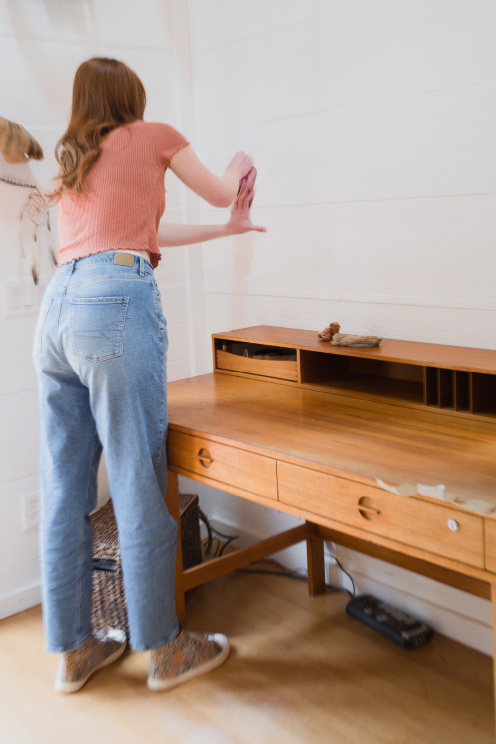 girl cleaning wall to prepare to hangup wall decals