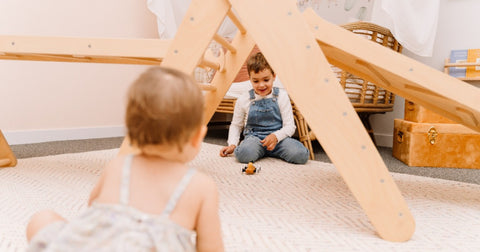 Indoor Play. Boy playing with Pikler Climbing Frame