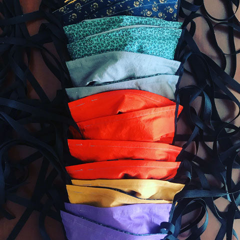 a row of pleated fabric face masks with ties