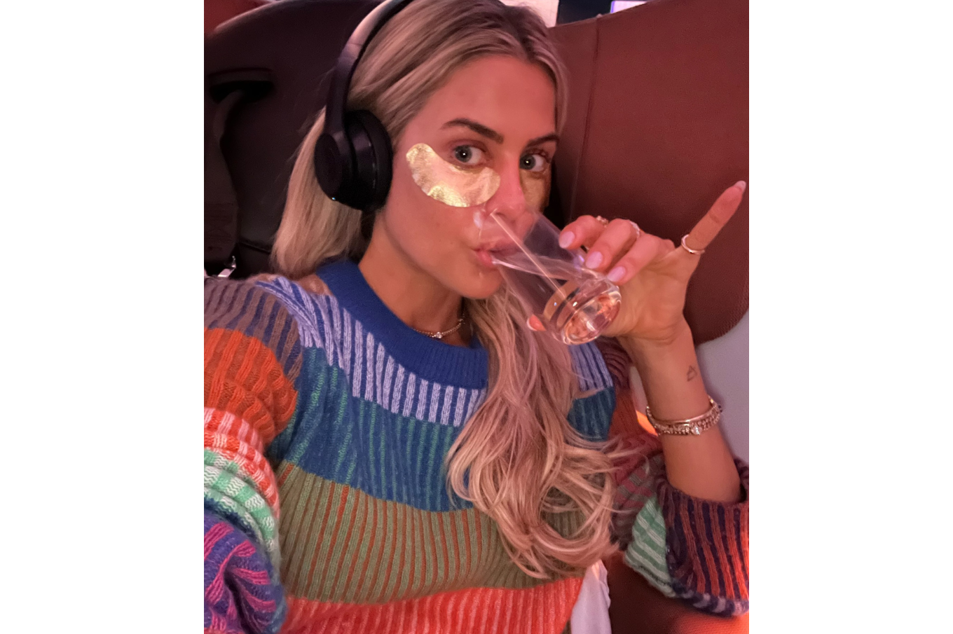 Logan on plane sipping wine with eye masks on