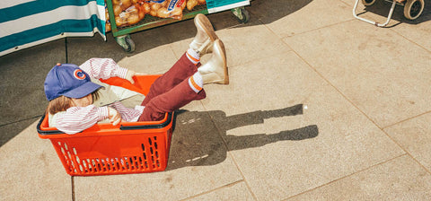 SMALL CHILD IN BASKET WEARING ZIG+STAR GOLD KIDS ROCKIT BOOTS