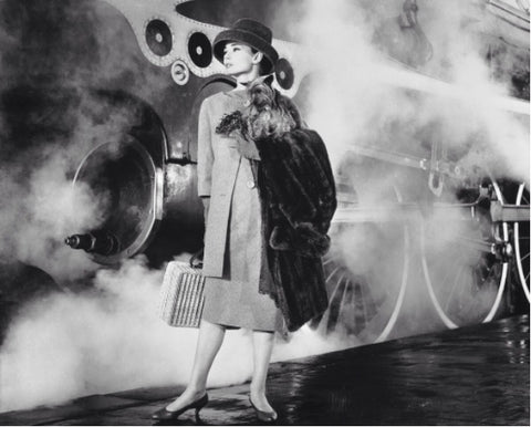 Audrey Hepburn stepping off a train with her Yorkie Mr. Famous