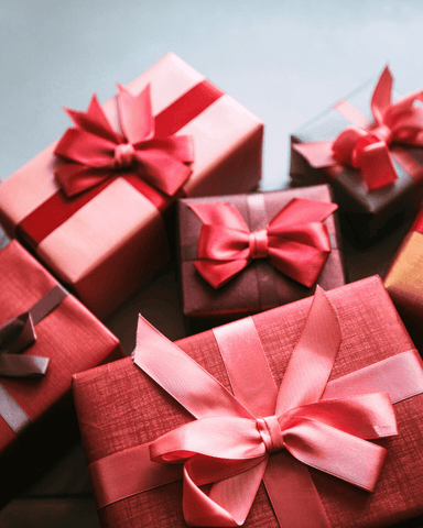 multiple beautiful giftbox wrapped with a red ribbon 