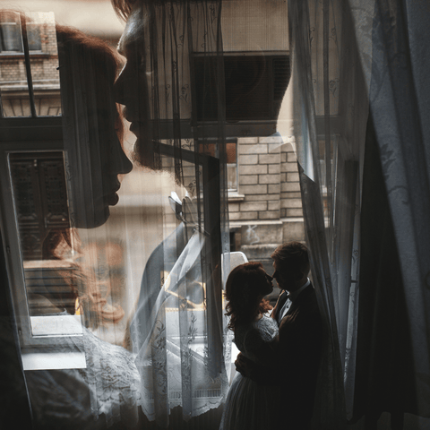 romantic couple kissing next to window