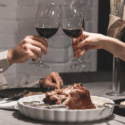 a couple having dinner and drinking red wine
