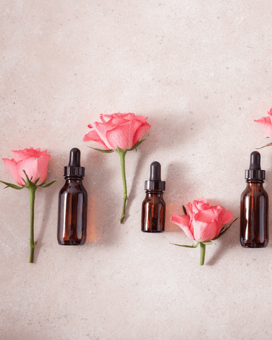 three flowers and essential oil bottles put next to each other