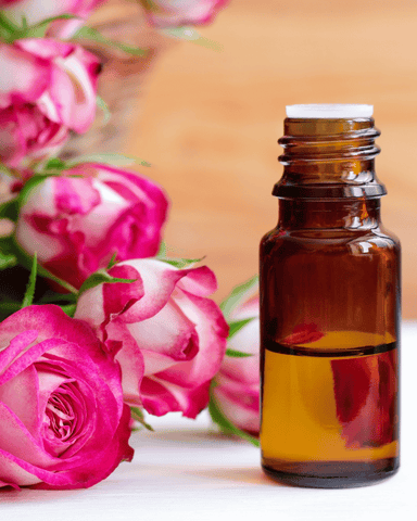 an opened essential oil bottle next to flowers