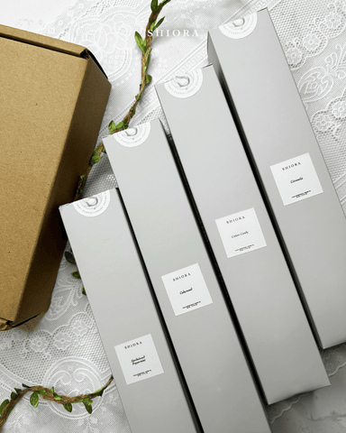 shiora's reed diffusers in beautiful gray packaging next to a carton box