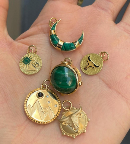 hand holding earth, taurus, and green medallion