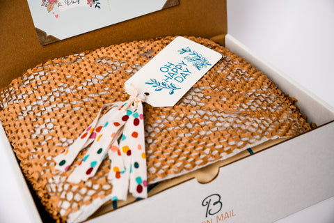 Care package packed with a hand-stamped tag with handmade fabric tassel.