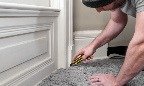 Man using OLFA LA-X knife to cut carpet flooring