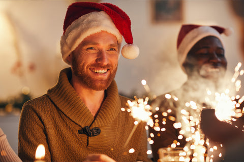 Man celebrating at work for Christmas next to colleague