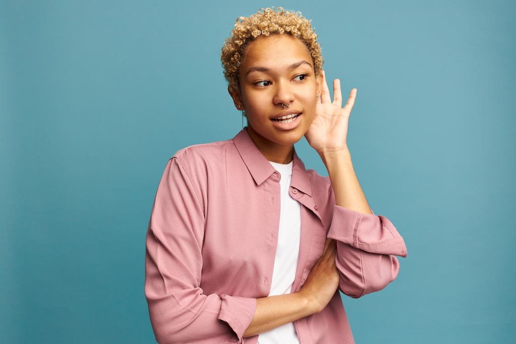 woman with short coily hair on light blue background