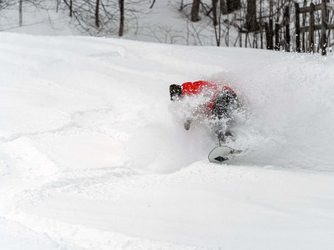 Person in deep snow riding a powder board