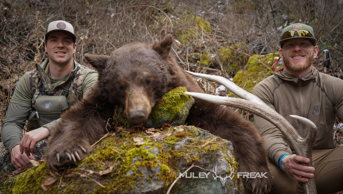 Aaron Van Woerkom sitting by a chocolate colored bear he shot in the idaho backcountry