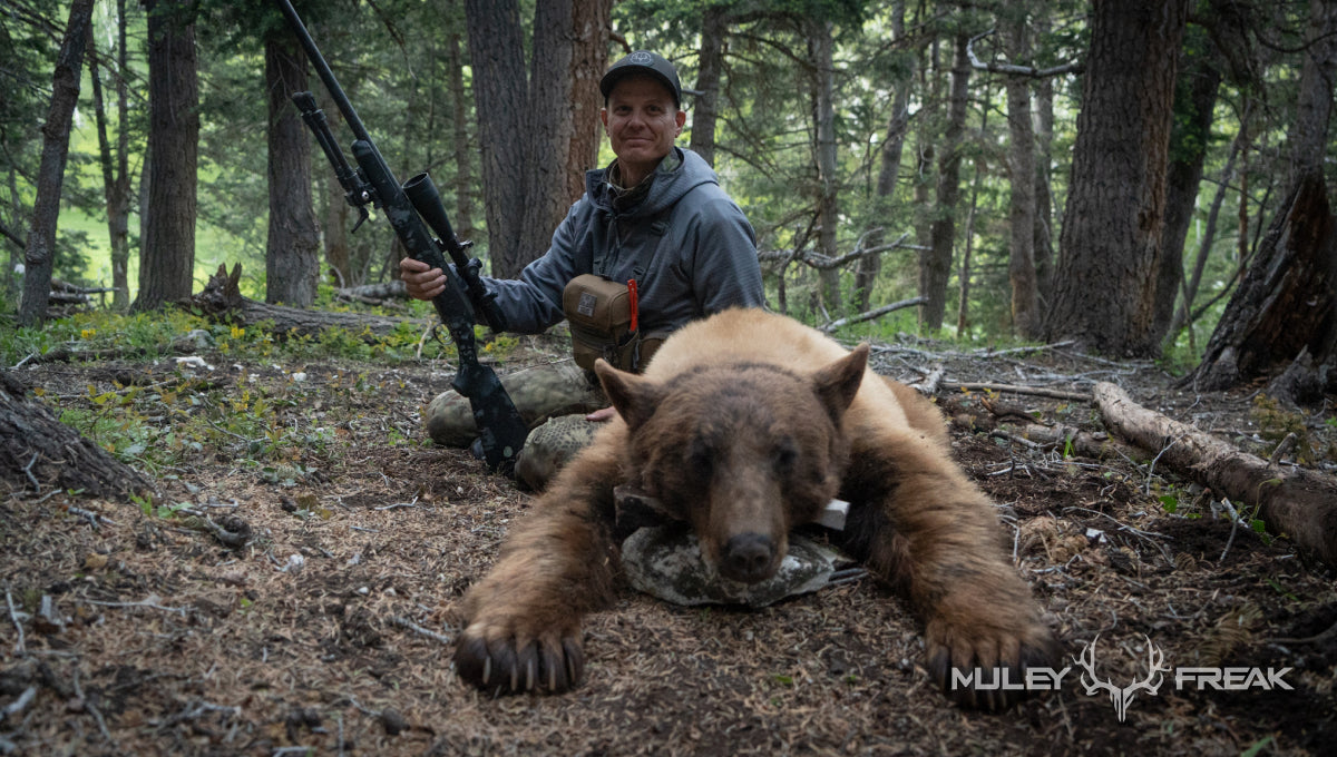 Clint Wirick sitting next to a Utah black bear that he harvested over bait