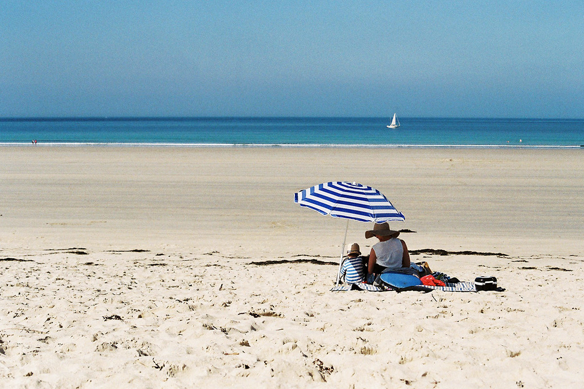 beach umbrella with family on sunny beach 