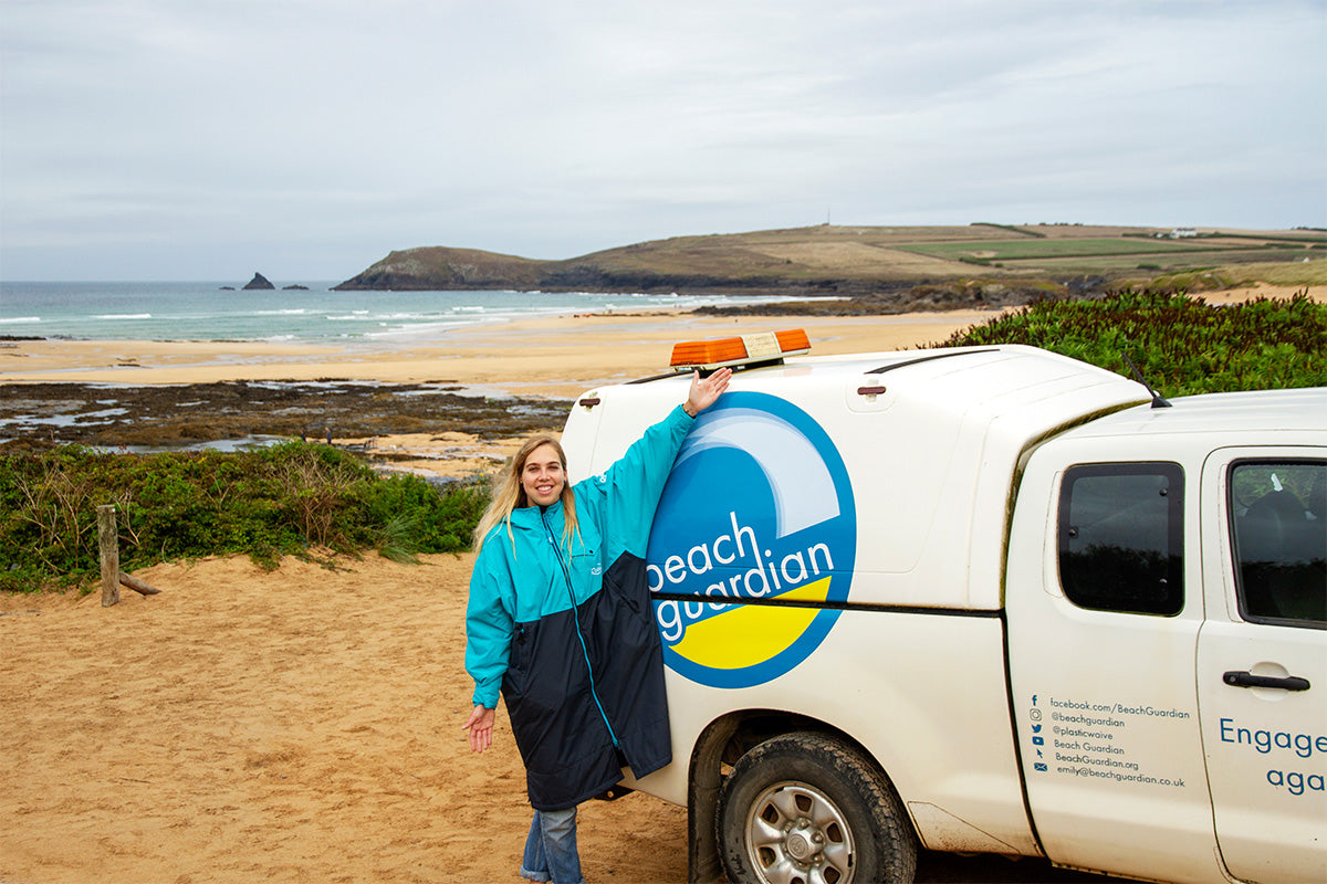 beach guardian co founder emily stands in front of beach guardian truck on the beach