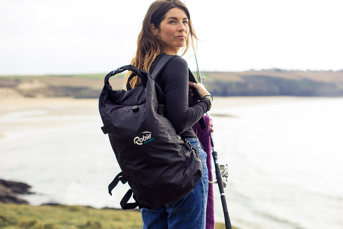 dark haired girl with backpack at the beach