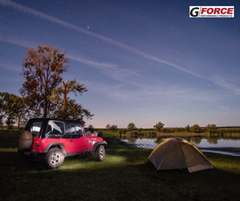 Red jeep overlooking lake and campsite