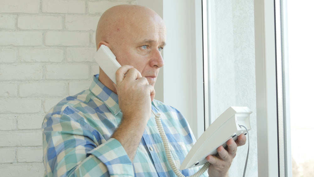 an elderly man using a home phone