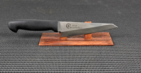 Ryuji Black Series Honesuki (boning/Utility) single bevel Japanese Kitchen Knife with one piece black polymer handle on a red wood stand