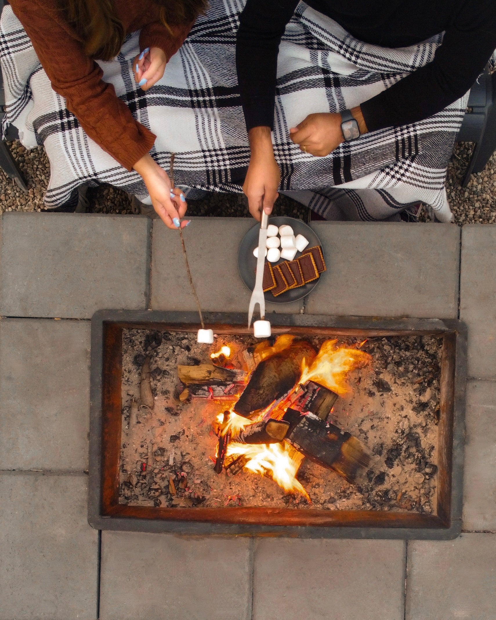 Smores around a cozy fire over an outdoor firepit