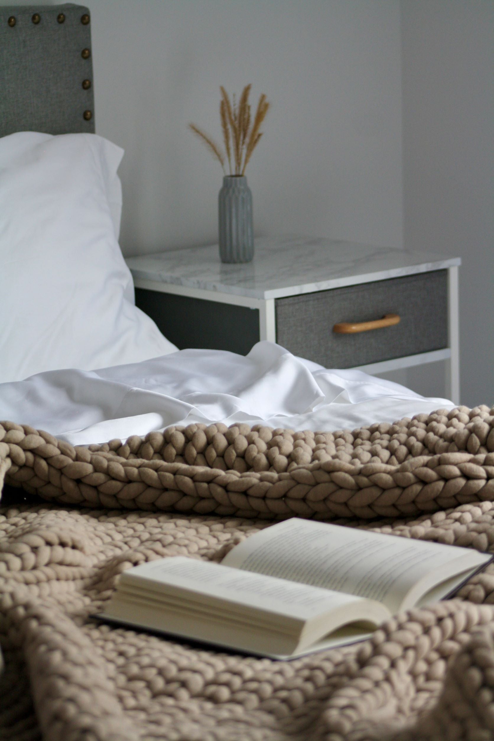 Book laying open on cozy bed