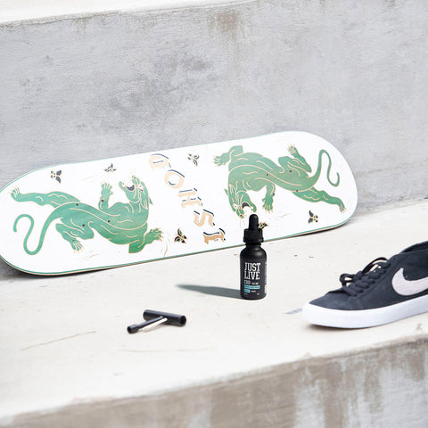 Bottle of CBD Oil Drops for Pain Recovery Near a Skateboard and Shoe