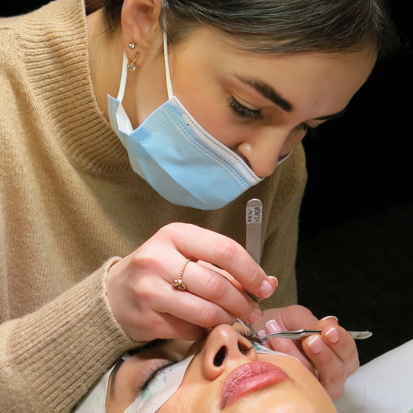 Lash Technician Performing Eyelash Extension Treatment on Model