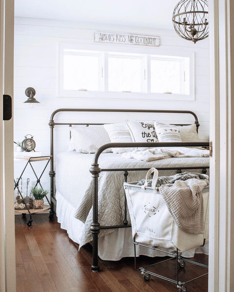 rolling laundry cart next to bed