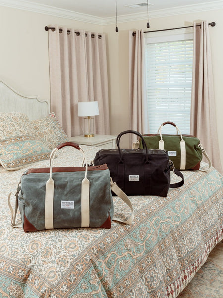 Weekender bags sitting on a bed