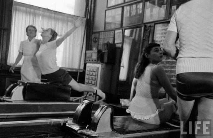 Historia pilatesu - kobiety ćwiczące pilates na maszynach