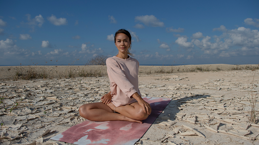 Praktyka jogi na plaży - pozycja kwiatu lotosu
