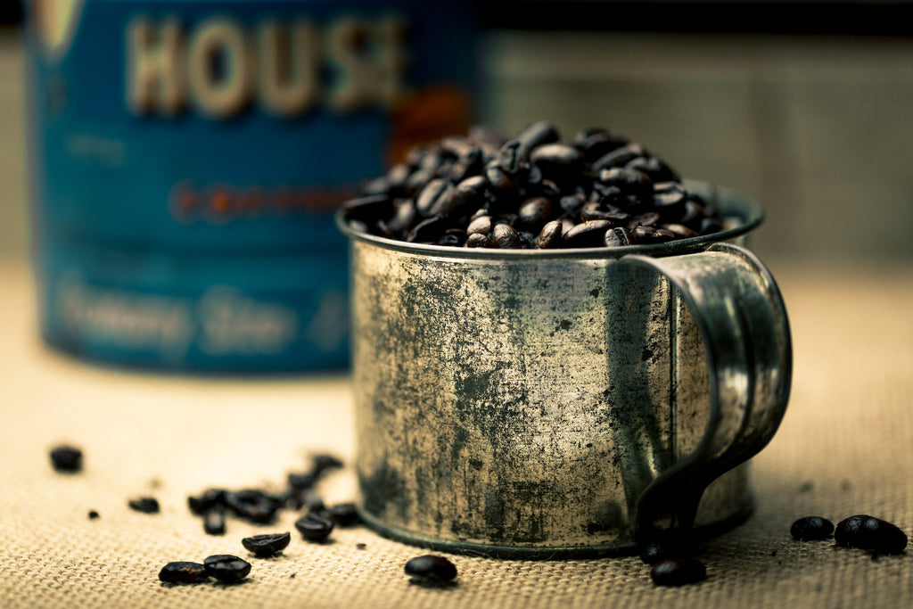 dark roasted coffee beans in iron cup