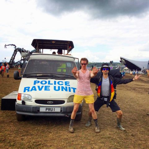 Two men at Glastonbury in front of a police rave unit