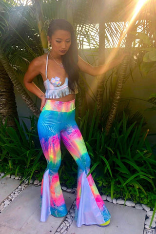 woman wears pastel rainbow bell bottoms with pride costume