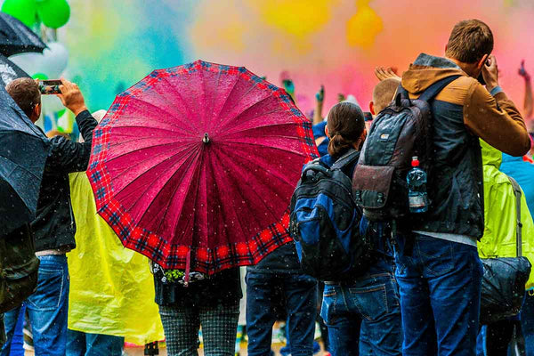 a crowd holding umbrellas at a rainy festival