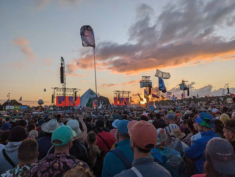 the Glastonbury festival crowd at sunset