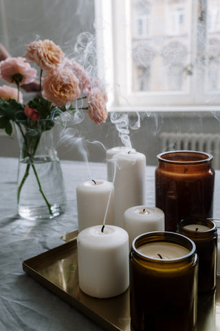 A collection of scented aromatherapy candles being extinguished