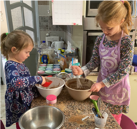 Two girls cooking cupcakes in a kitchen using Purdate date sugar.