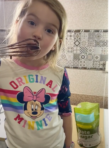 Kid licking purdate cake batter off the spatula.