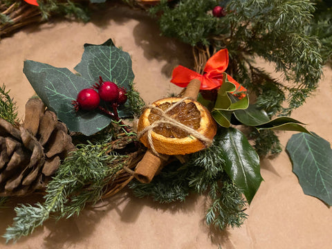 Tying the orange slices and cinnamon together to decorate the ring