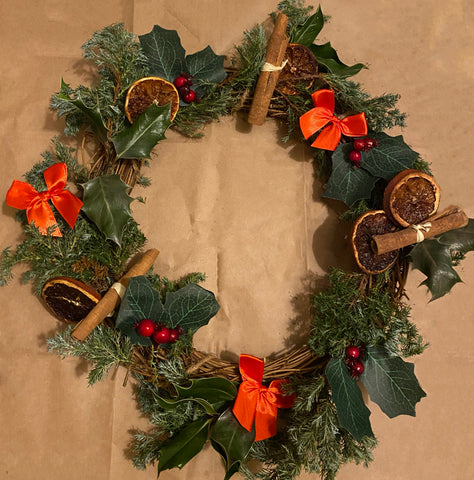 Decorated wreath ring with cinnamon, artificial holly sprigs, firn leaves and real holly leaves