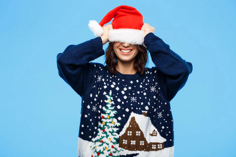 Smiling lady in Christmas jumper with Santa hat pulled down over eyes
