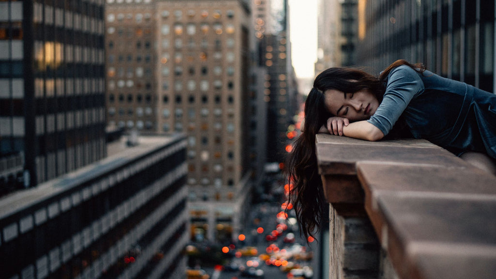 girl sleeping on her balcony that overlooks new york city streets